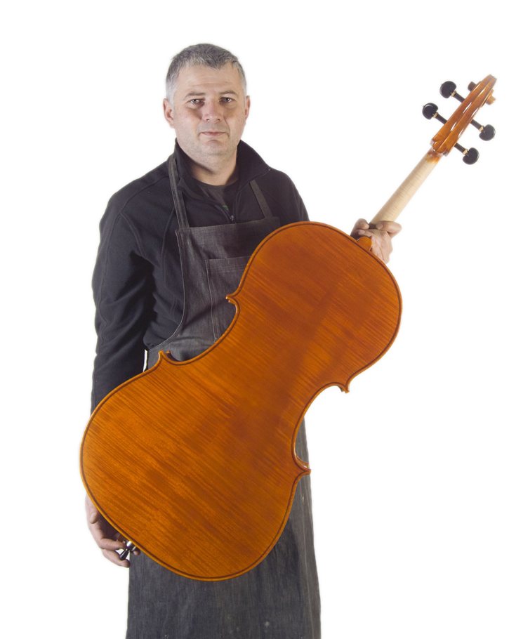 Gregorio Martini holding a cello he made